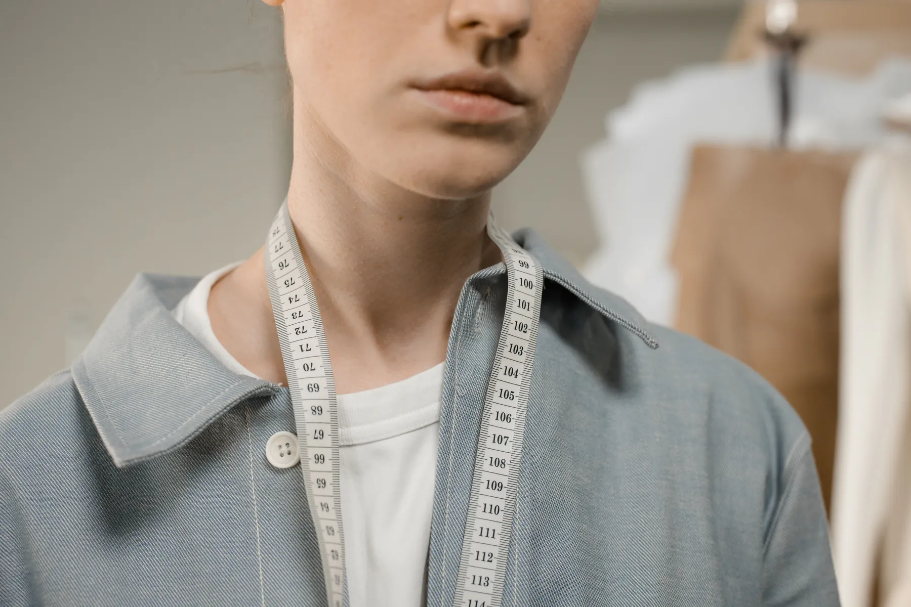 A tape measure around the collar of a pale workwear shirt