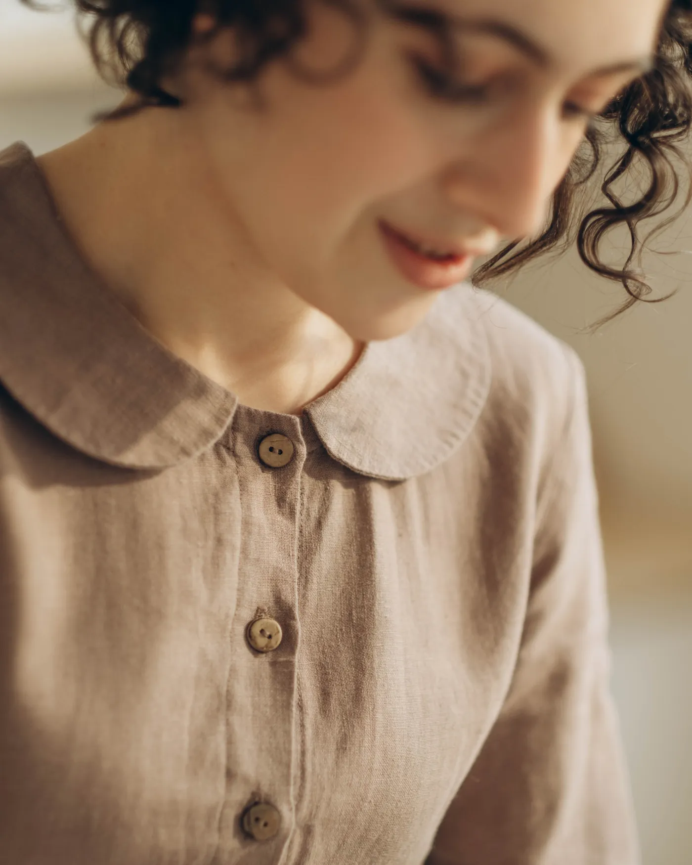 Close frame of a linen garment with horn buttons in warm daylight
