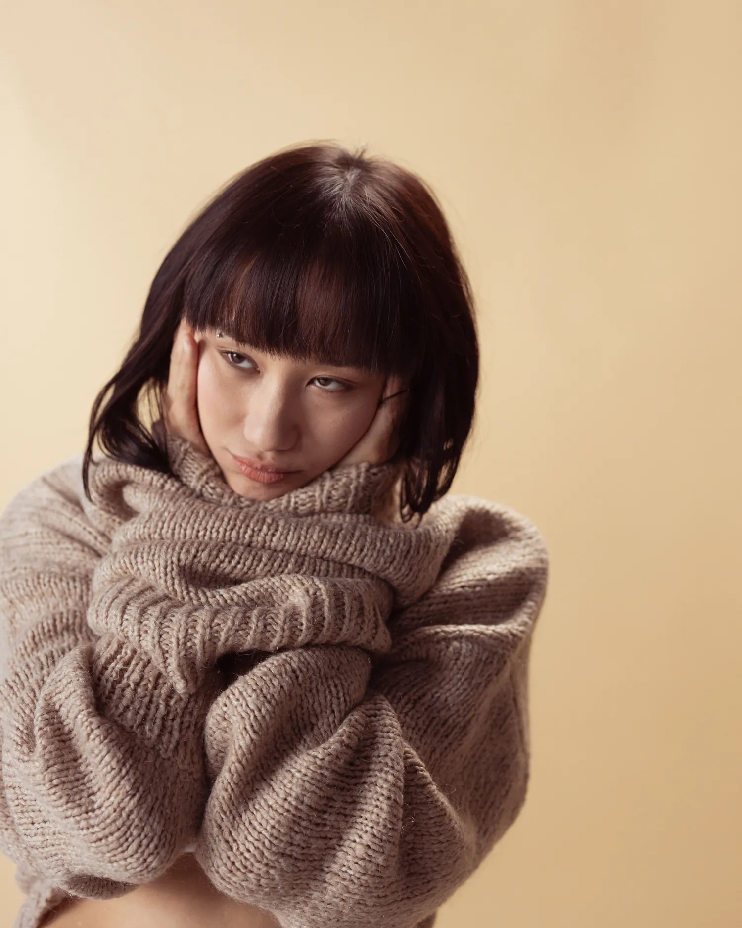 Fold Collar Knit — Model wearing an oatmeal knitted sweater with a deep folded collar