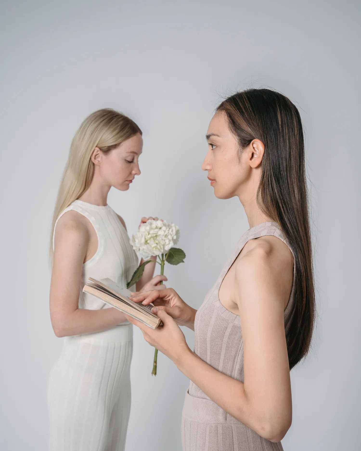 Two models in ivory and clay ribbed knit sets, facing one another