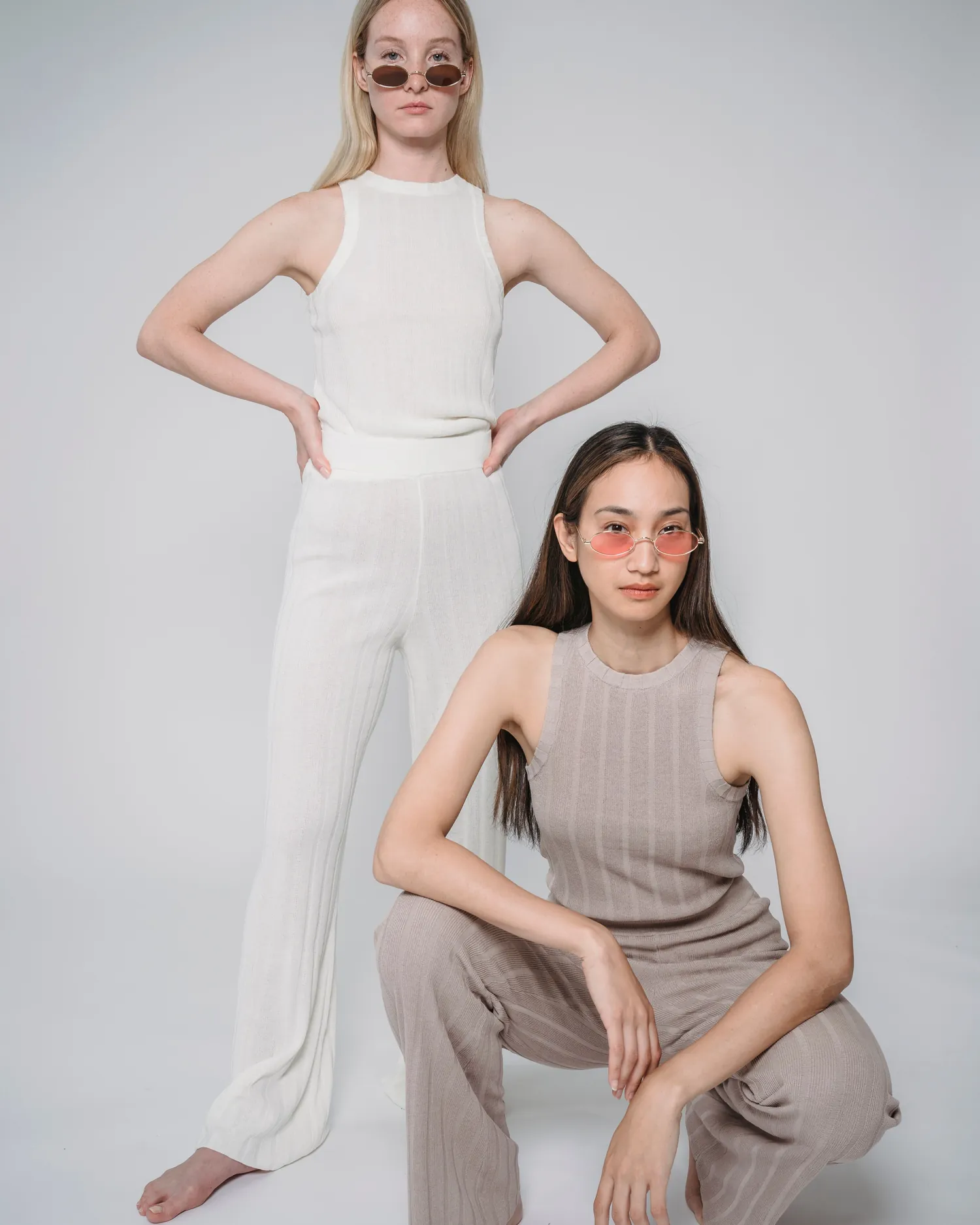 Rib Trouser — Two models standing in ivory and clay ribbed knit sets