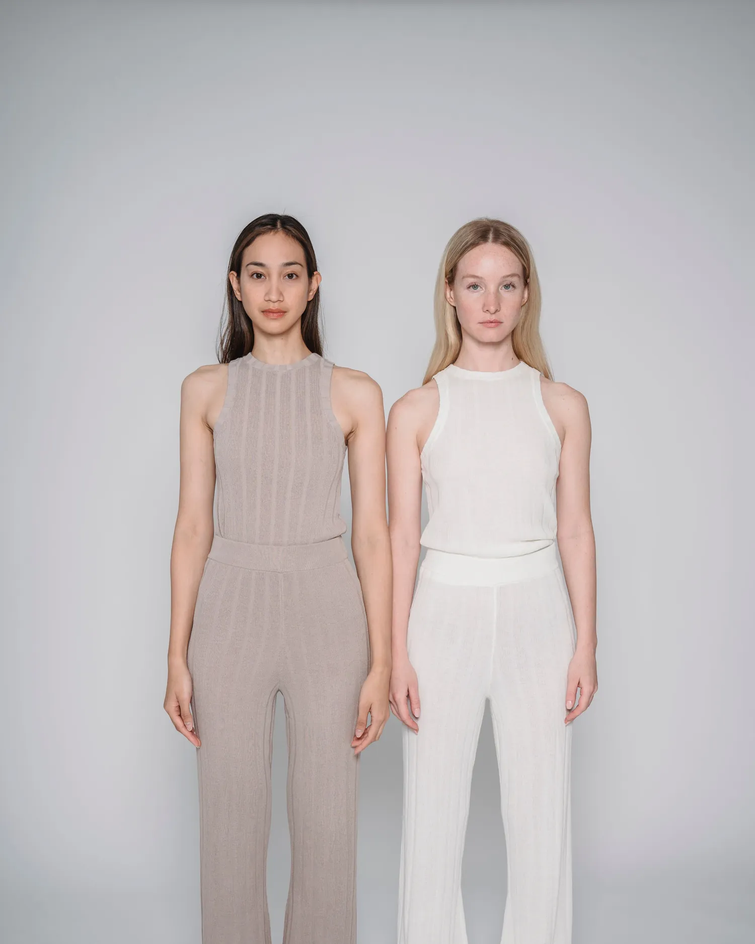 Two models standing side by side in ivory and clay ribbed knit sets