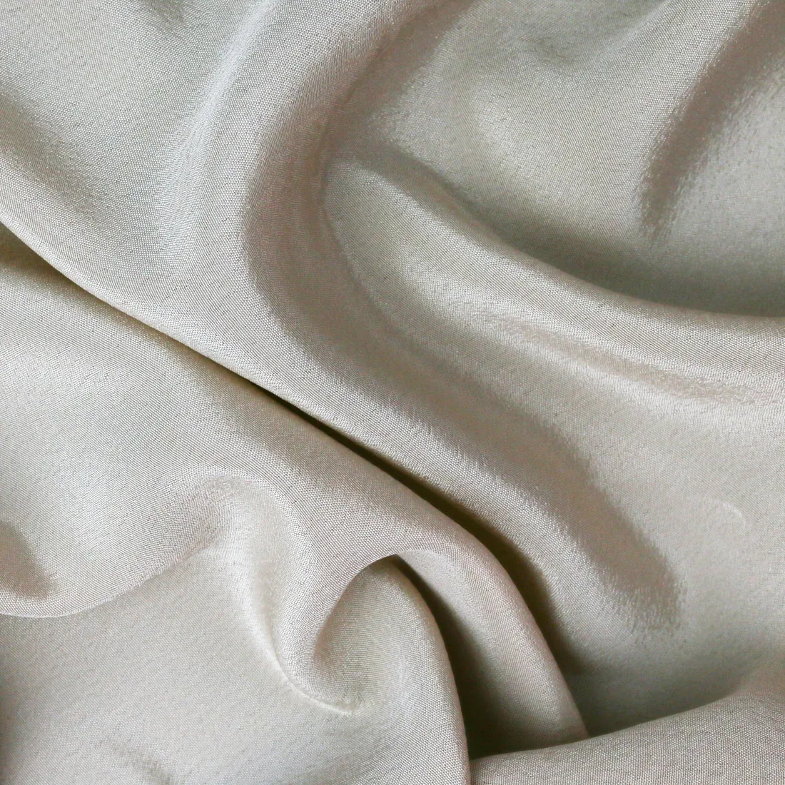 Close study of bone-coloured raw silk in soft folds